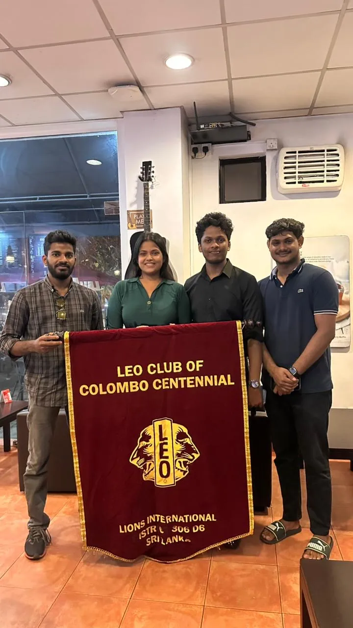Leos holding the club banner inside the café